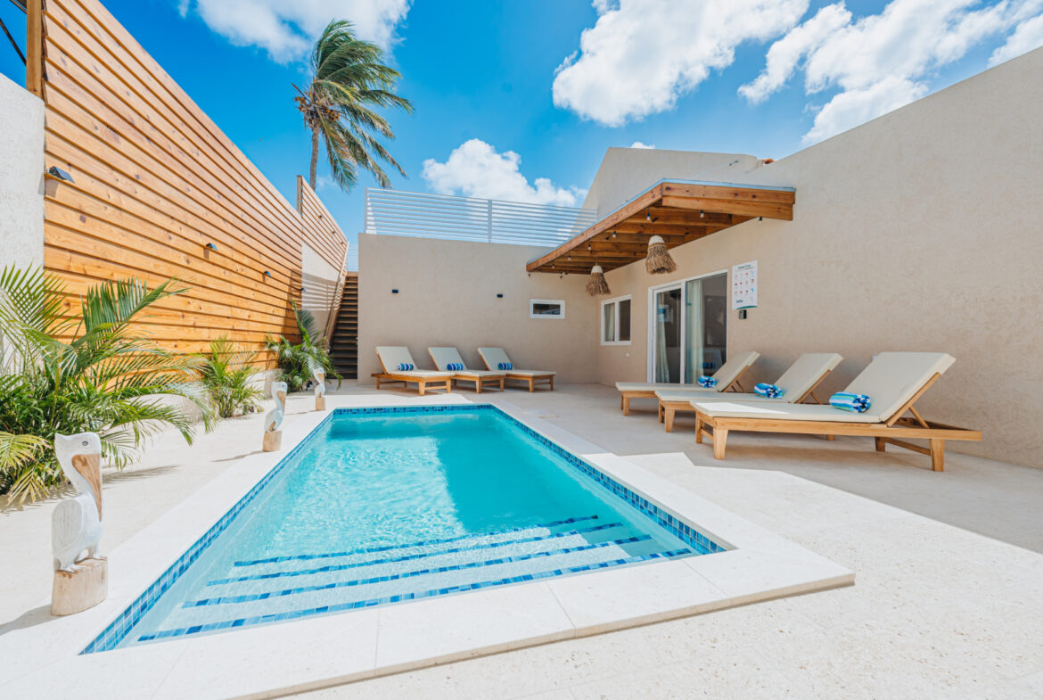 Poolside patio with lounge chairs and independent studio unit, Seaside Modern Villa, Aruba