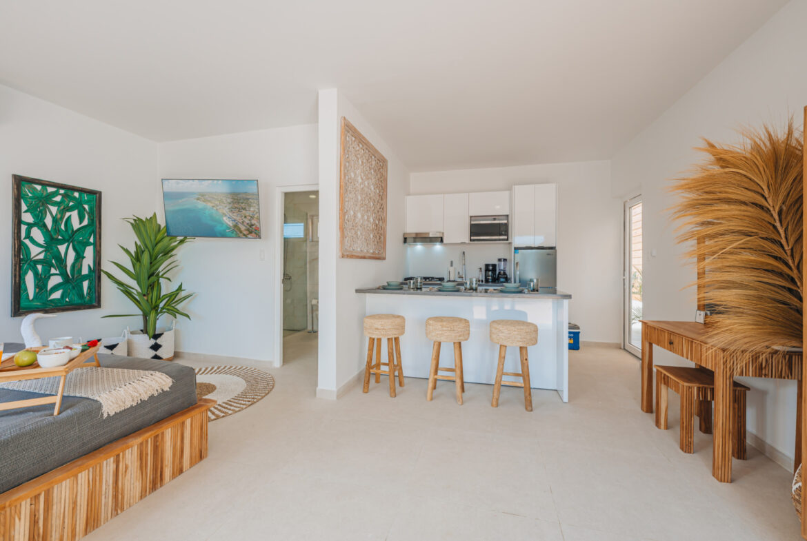 Open-plan kitchen and living area with rattan bar stools and coastal decor, Seaside Modern Villa, Aruba