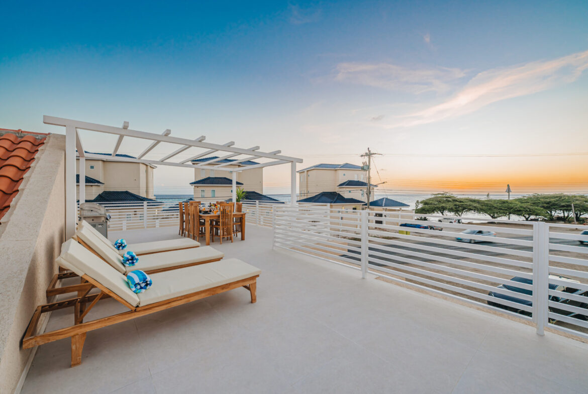 Sunset ocean view from the rooftop terrace with pergola and lounge chairs, Seaside Modern Villa, Aruba