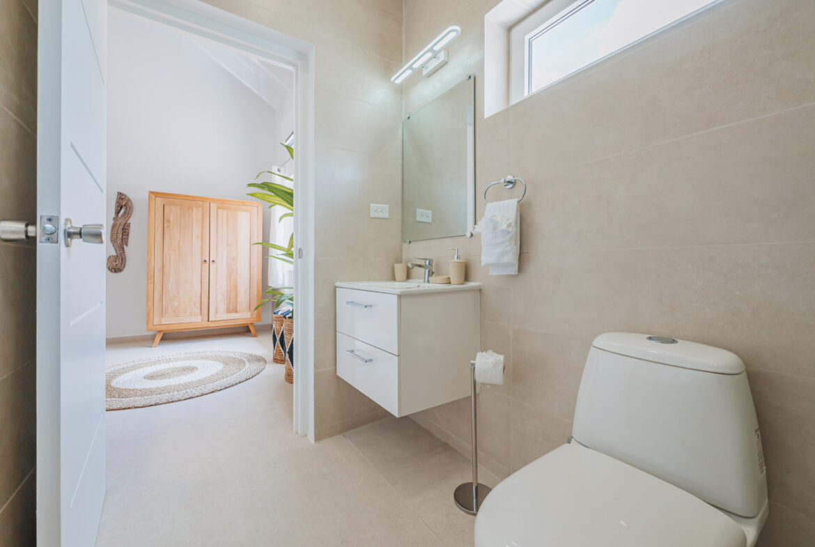Bathroom with floating vanity and wardrobe visible through doorway, Seaside Modern Villa, Aruba